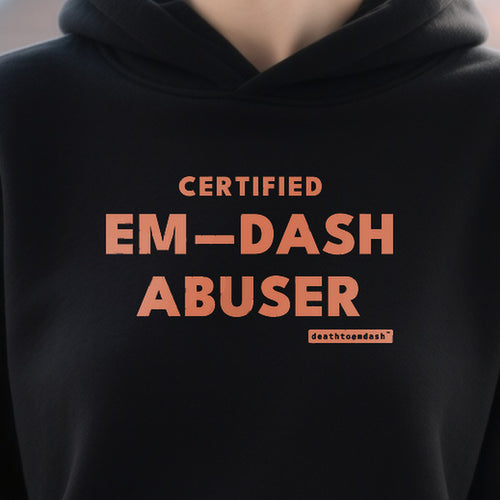 Certified Em Dash Abuser design shown close up on a black unisex hoodie