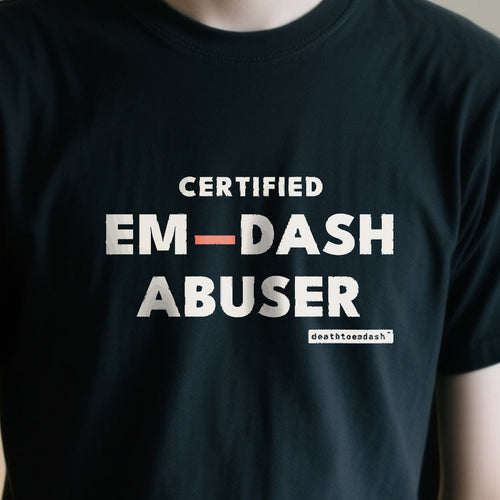 Certified Em Dash Abuser design shown close up on a black unisex t-shirt