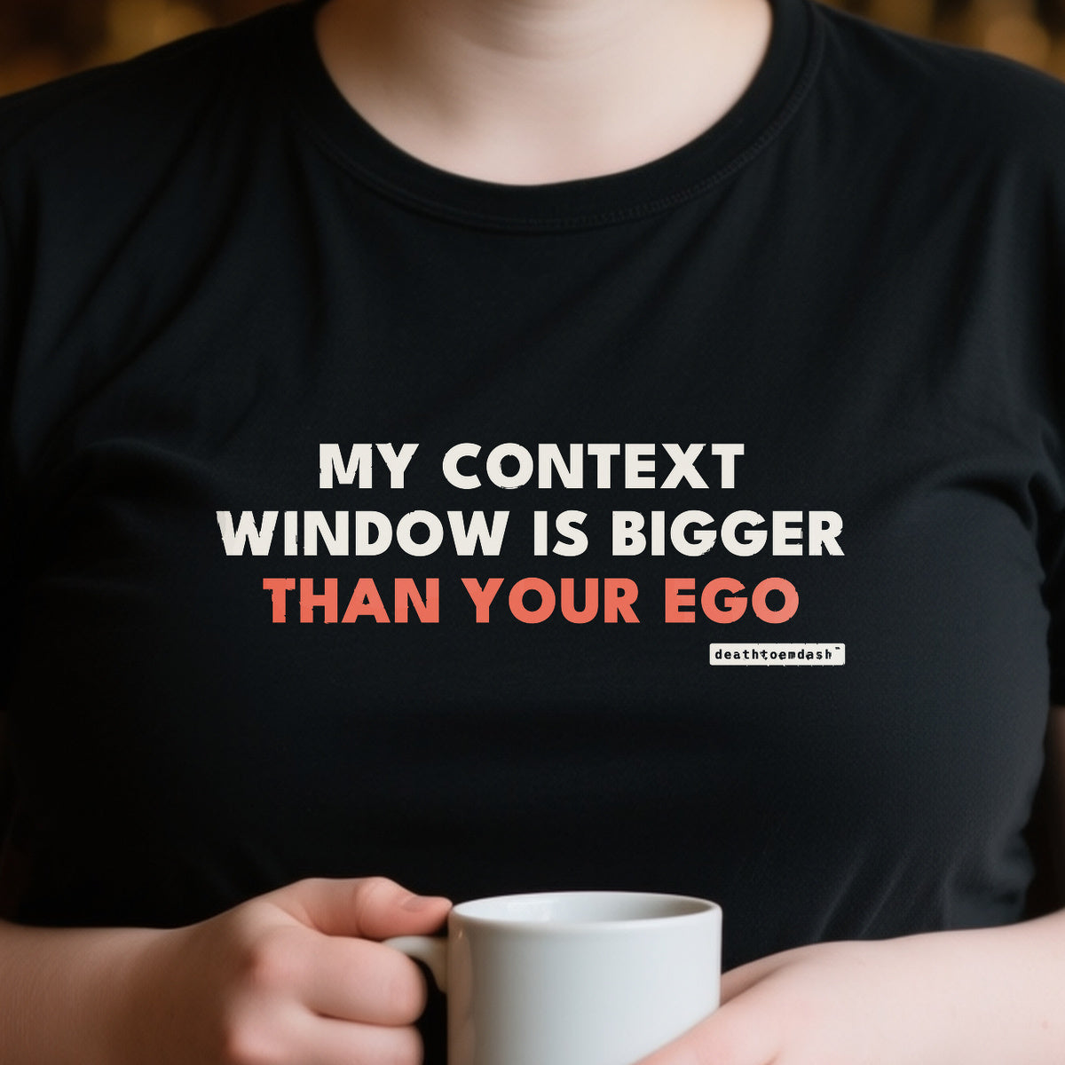 My Context Window Is Bigger Than Your Ego design shown close up on a black unisex t-shirt