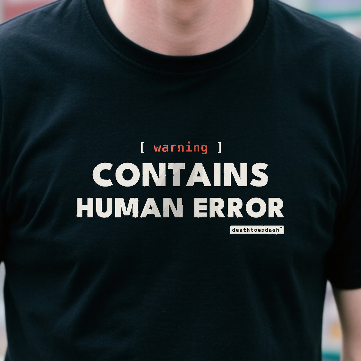 Warning Contains Human Error design shown close up on a black unisex t-shirt